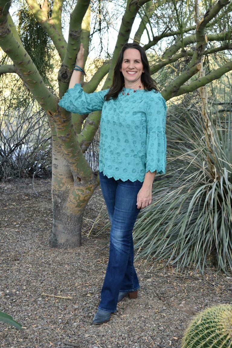 Robin Singer Realtor Full Length Standing Photo holding onto a Palo Verde tree and welcoming you to Tucson, Arizona, where you can find home. Contact me now.